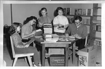 Black and white photo of volunteers cataloging books donated during the book drive.