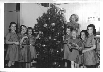 Black and white image of the Troop 76 of Dix Hills decorating the tree at the Melville library