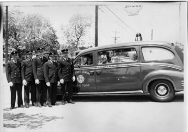 Black and white image of Firefighters in front of rescue squad vehicle in 1958