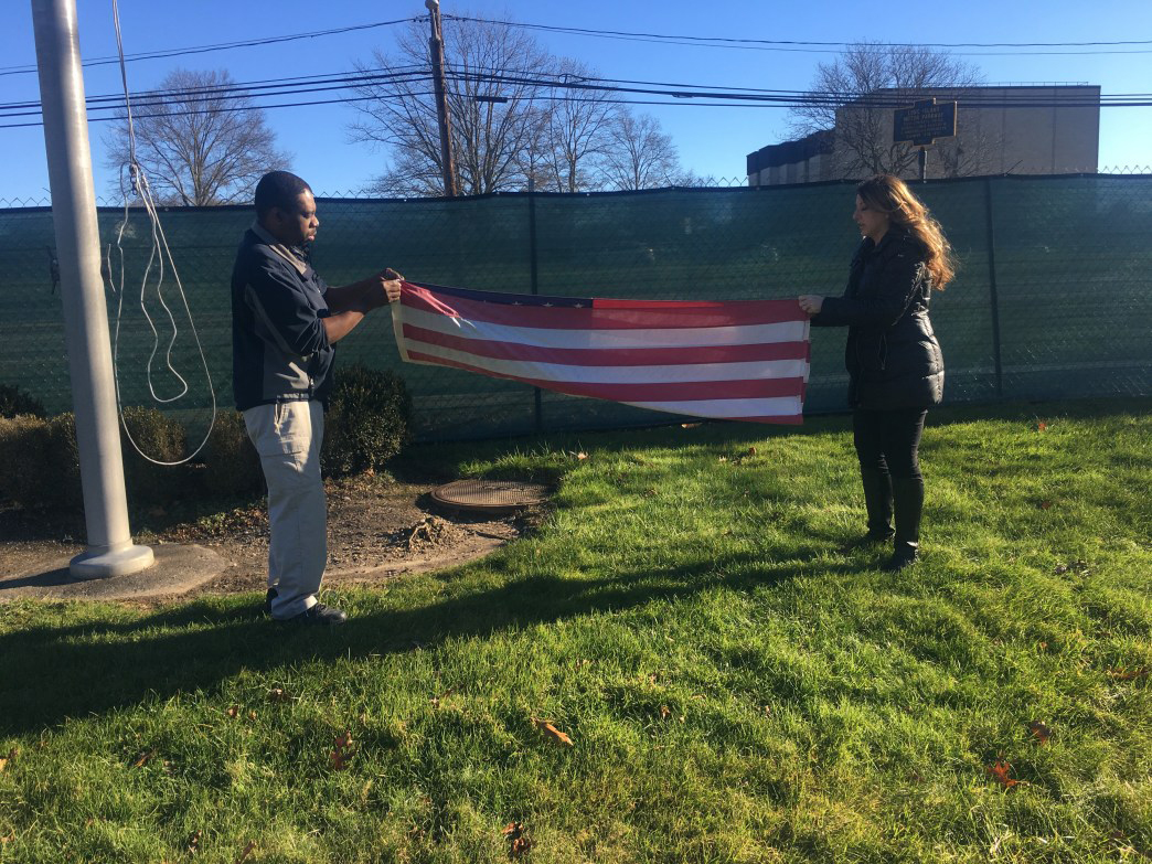 Two people removing American Flag at Dix Hills