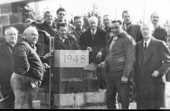 Black and white image of a group of men celebrating the Fire department cornerstone in 1948