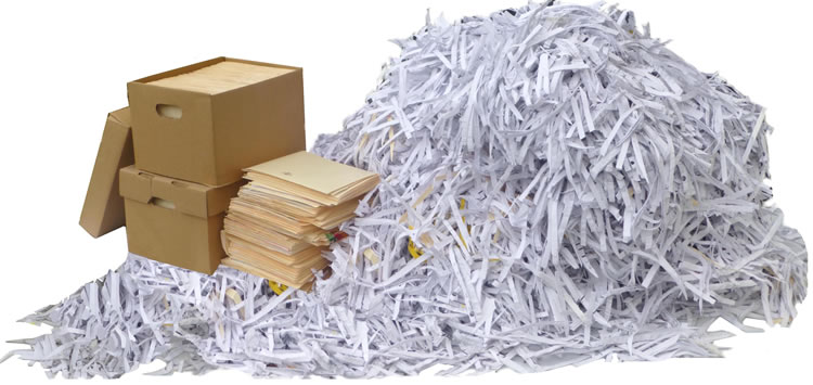 Boxes and folders filled with paper. Pile of shredded paper beside them.