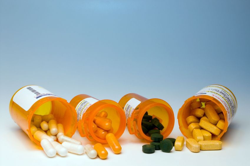 Image of medications spilling out of pharmacy prescription bottles. 