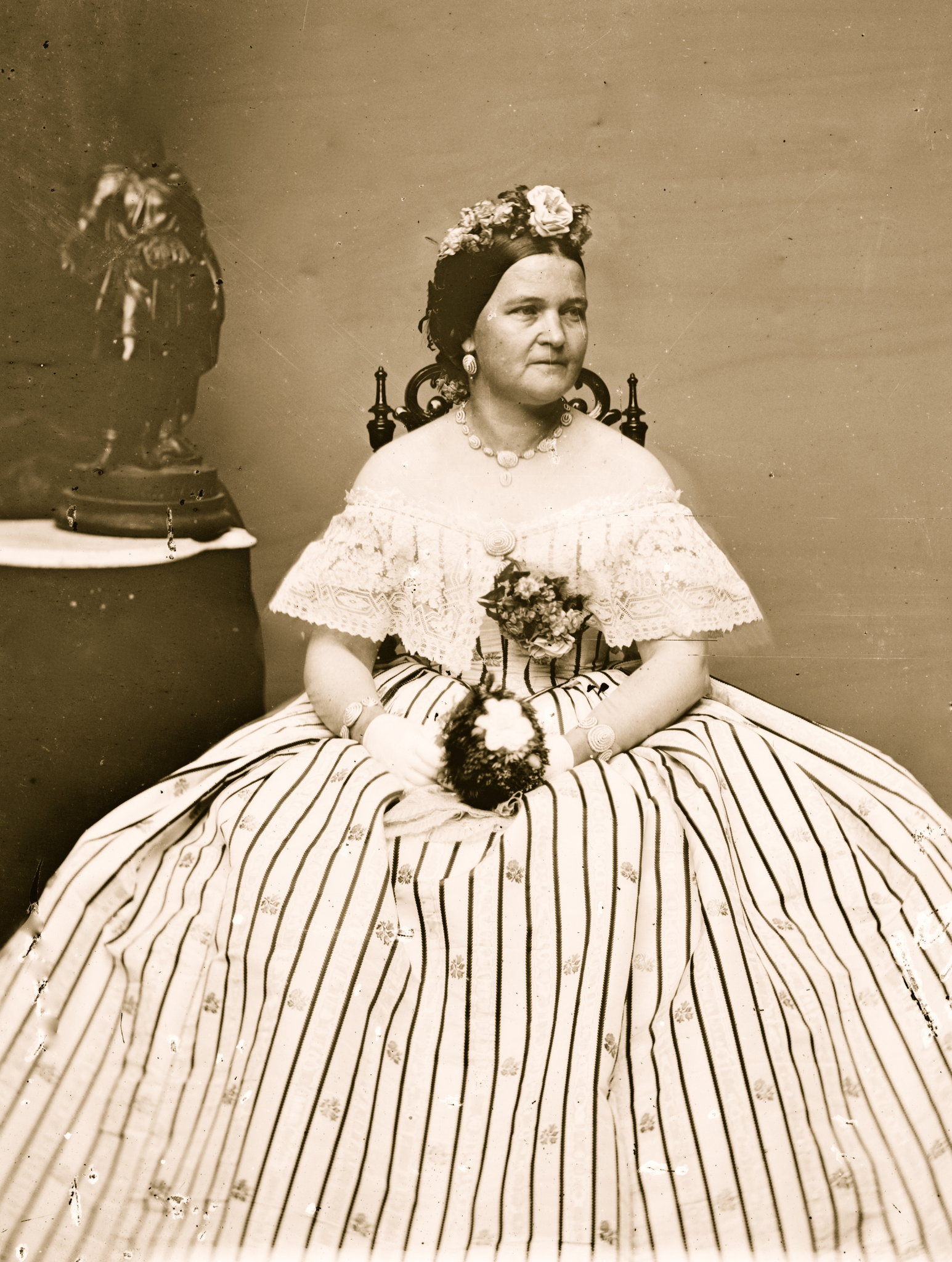 Sepia image of Mary Todd Lincoln in a dress looking off to the right. She is dressed in white.