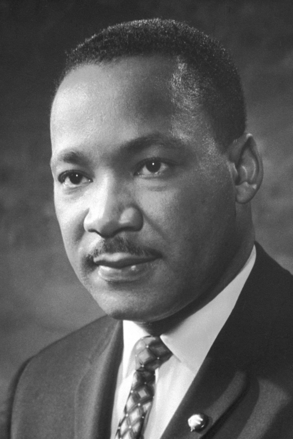 Black and white photo of Dr. Martin Luther King Jr. in a suit and tie.