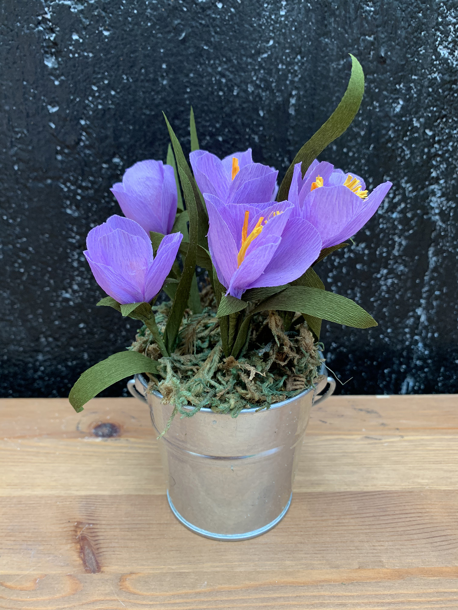 A flower pot of purple crocuses made out of crepe paper.