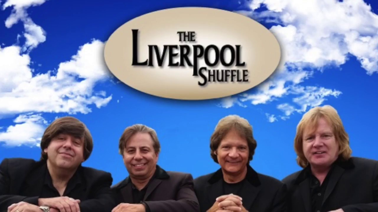 Photograph of the 4 male members of the Liverpool Shuffle Beatles cover band. They are pictured from the chest up, standing shoulder to shoulder with in front of a blue sky with clouds. The words "The Liverpool Shuffle" in an oval above their heads. 