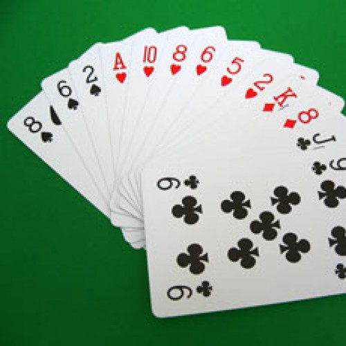 photo of a deck of cards fanned out on a green background.