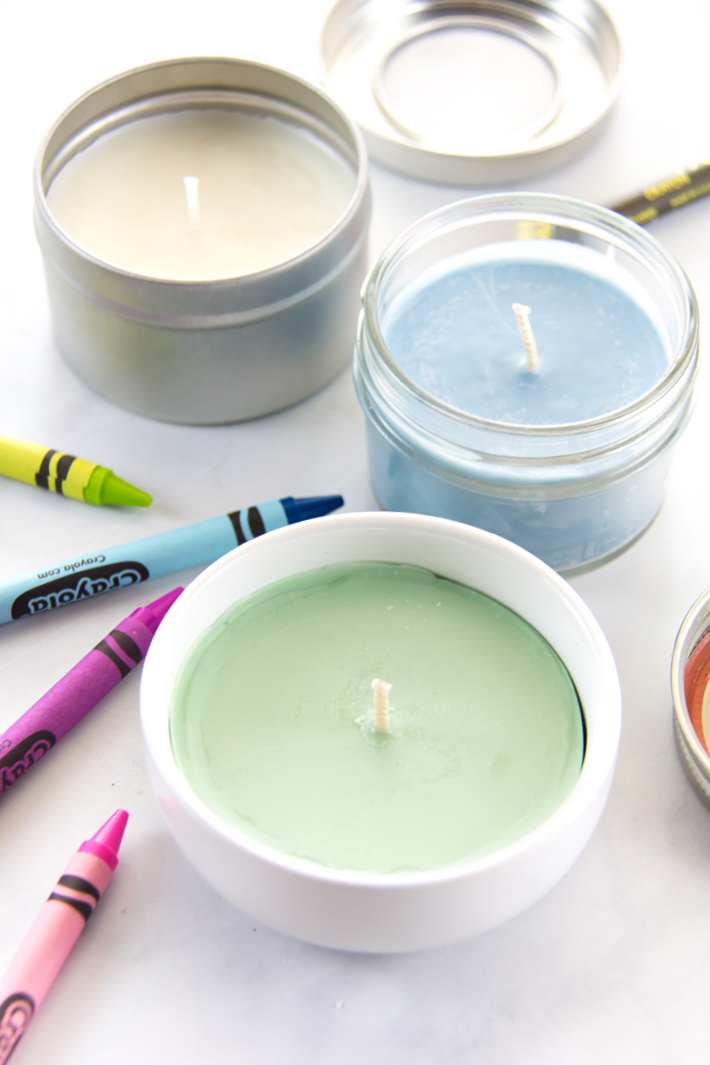 image of multicolored candles surrounded by crayons on a white table.