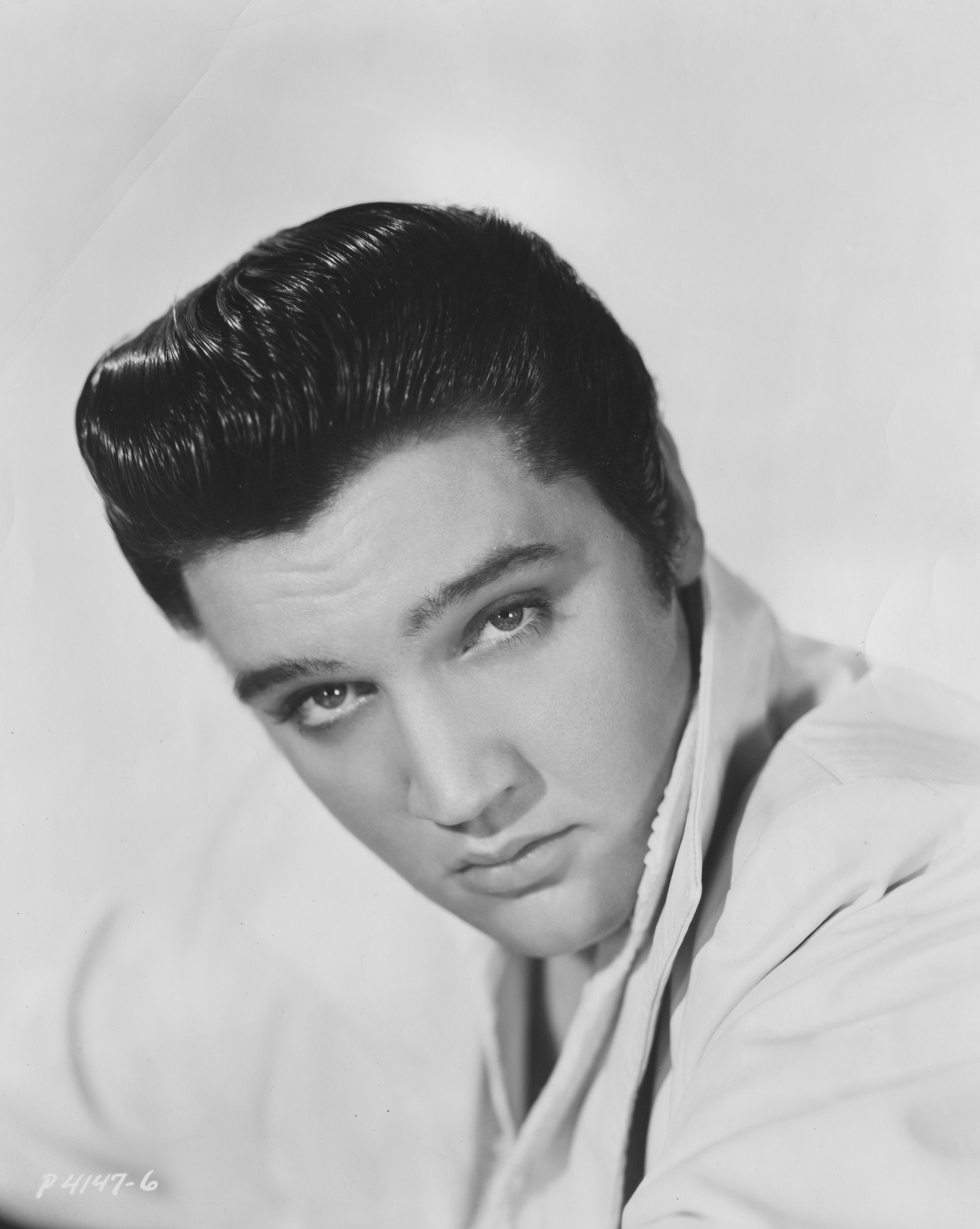 Black and white photo of American singer, Elvis Presley.