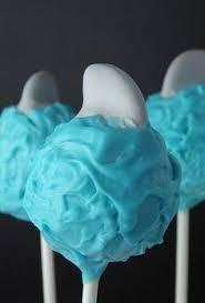 Photo of cake pop covered in blue icing with a fondant fin sticking out of the top to look like a shark fin coming out of the water.