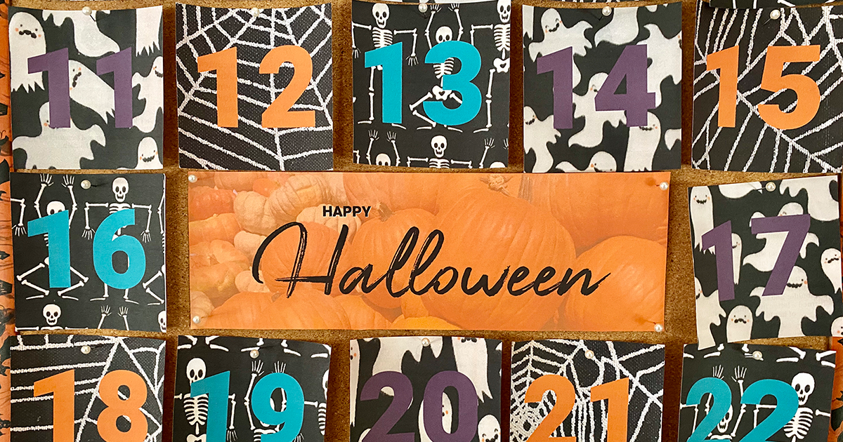 Image of a Halloween countdown calendar with various numbers painted on spooky black and white cutout, the center reading Happy Halloween over an image of pumpkins.