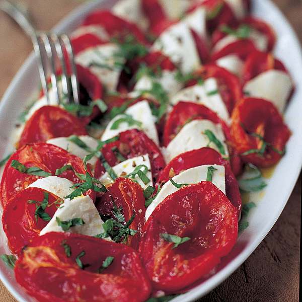 Plate of food featuring tomatoes, mozzarella and basil. 