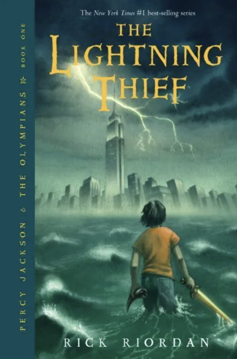 Image of the original cover of Percy Jackson: The Lightning Thief, featuring Percy in the sea looking at skyscrapers and a bold of lightning, holding a gold sword in his right hand, and a horn in his left, looking away. 