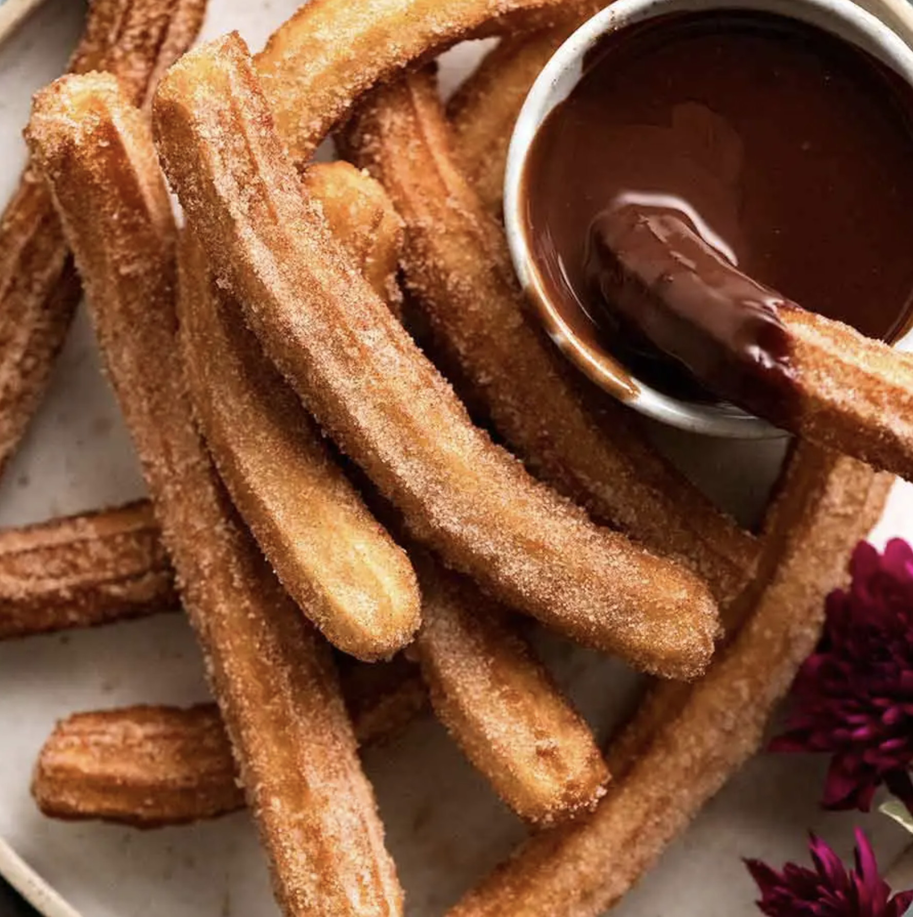 Image of churros and a chocolate dip in the top right corner from an aerial view.