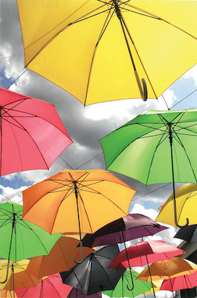 Colorful umbrellas suspended in mid air by thin wires with the sky for a background