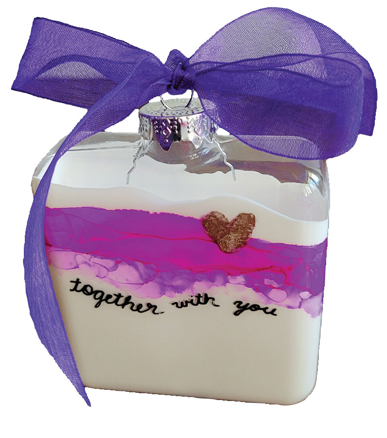 Jar filled with colorful sand. Printed on the jar are words that state, "Together With You". Top of jar has a purple bow. 