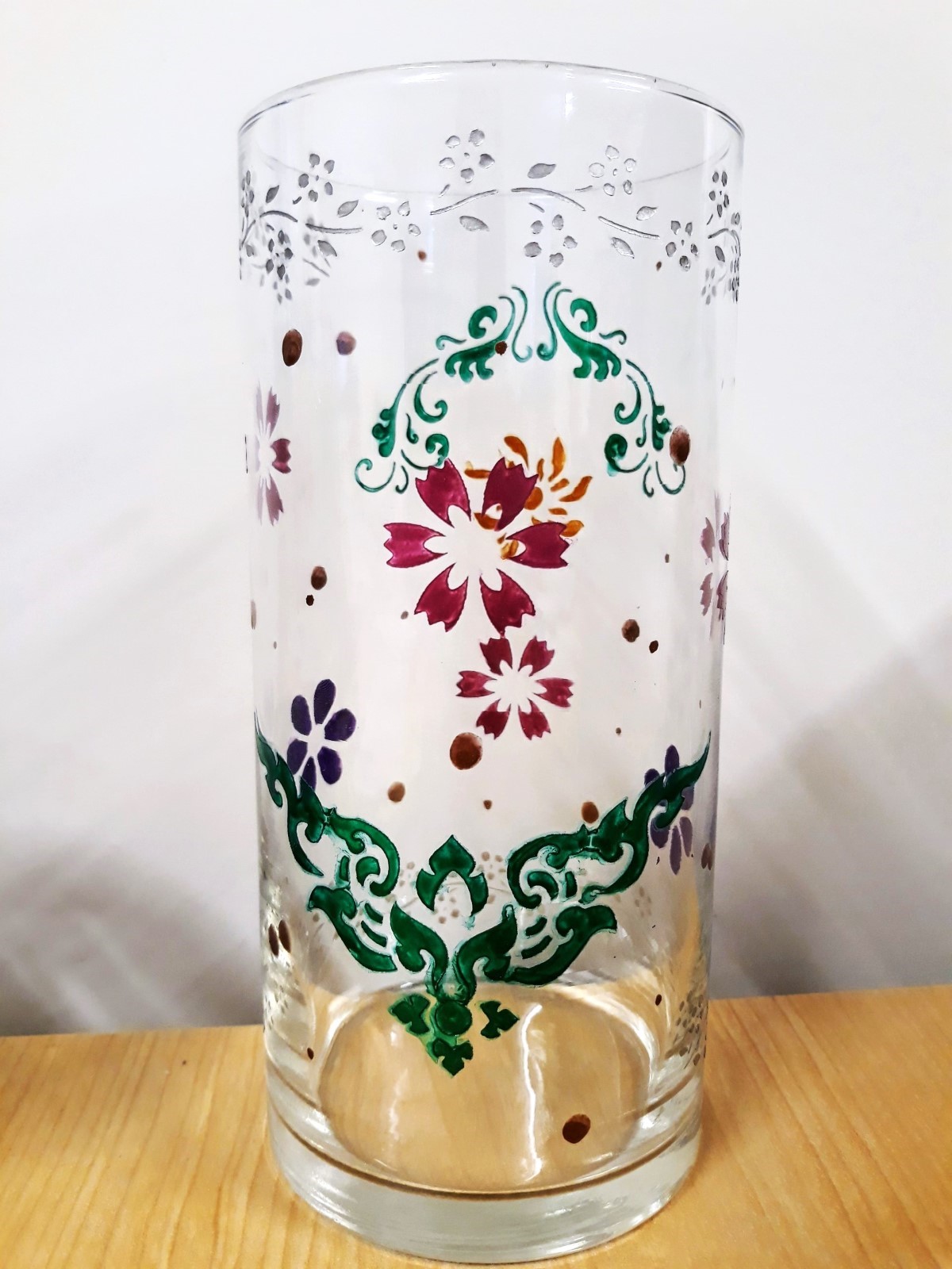 Image of the craft featuring a glass vase with colorful painted stenciled flowers and design.
