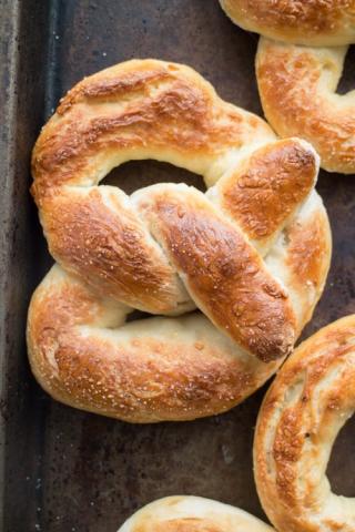 Picture of a freshly made soft pretzel on a sheet pan.