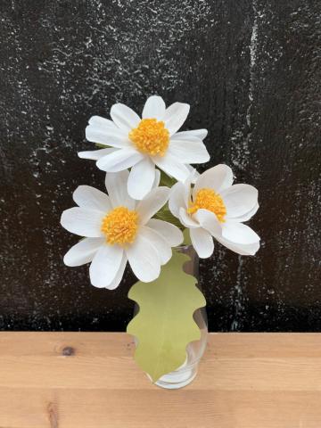 Image of 3 daisies made out of crepe paper. 