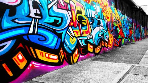Image of a wall of a building with graffiti art.