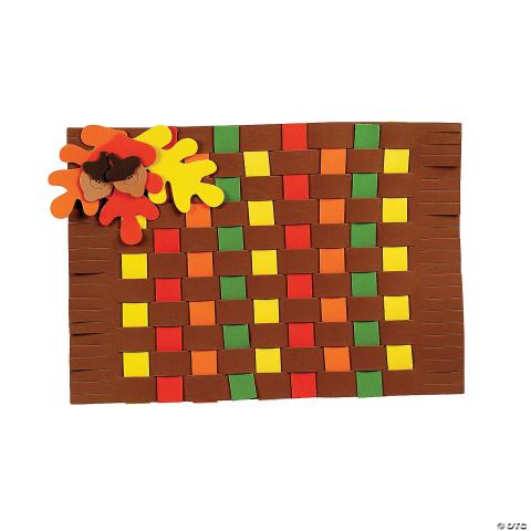 Image of a woven placemat made out of felt pieces with felt leaves and acorns in the top left corner. 