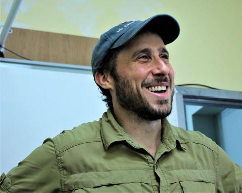 Image of Matt Green, Documentarian. Man with a trimmed beard and mustache wearing a baseball cap smiling. 