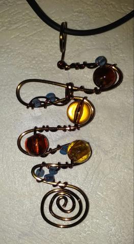Image of necklace with a pendant of twisted wire and beads. 
