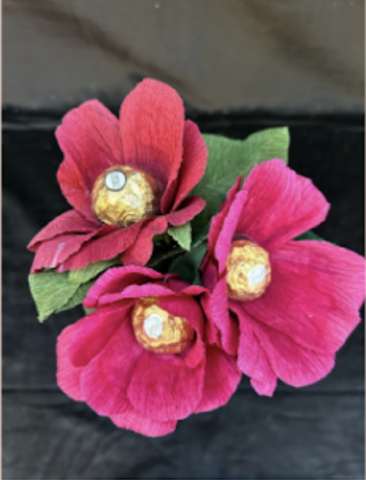 Image of the craft featuring a purple crepe paper flower with a Ferrero Rocher wrapped candy as the center of the flower. 