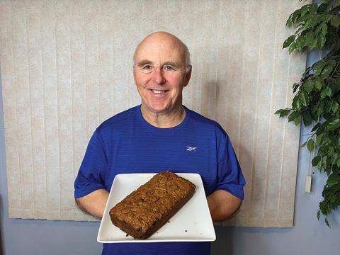 Image of Chef Rob holding a loaf of bread on a plate. 