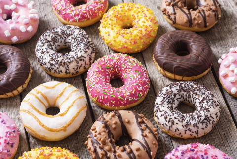 Various colored donuts on a wood table.