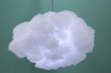 A hanging cloud lantern that is faintly blueish white, over a blue backdrop.