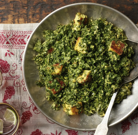 Saag Paneer, a green dish in a silver bowl, atop a table.
