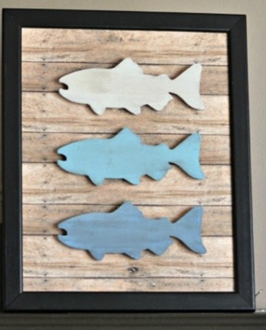 Rustic fish frame with three fish on it, the top one white, the middle light blue, and the bottom a darker blue.