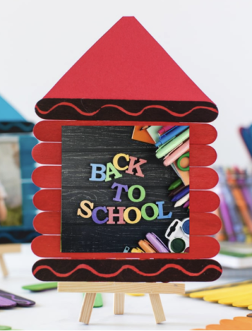 Red popsicle sticks stacked on an easel to look like a red crayon, with the words BACK TO SCHOOL colorfully on top of it.