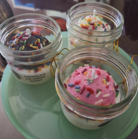 3 ice cream candles with wax sprinkles, the front one is strawberry, the left is chocolate, and the back is vanilla.