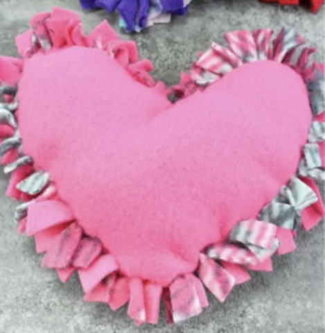 A no-sew pink felt heart pillow with frills on the edges.