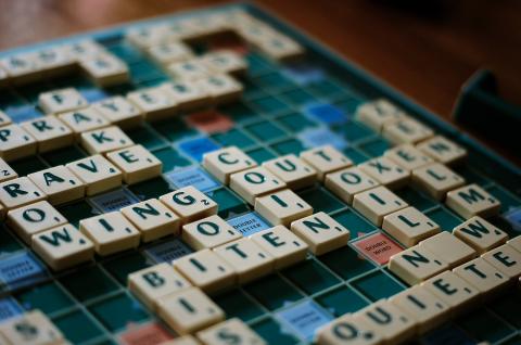 Image of Scrabble Board with letter tiles on it.