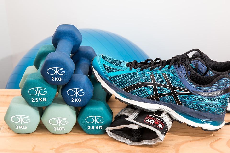 Stack of shoes, weights, and other workout equipment