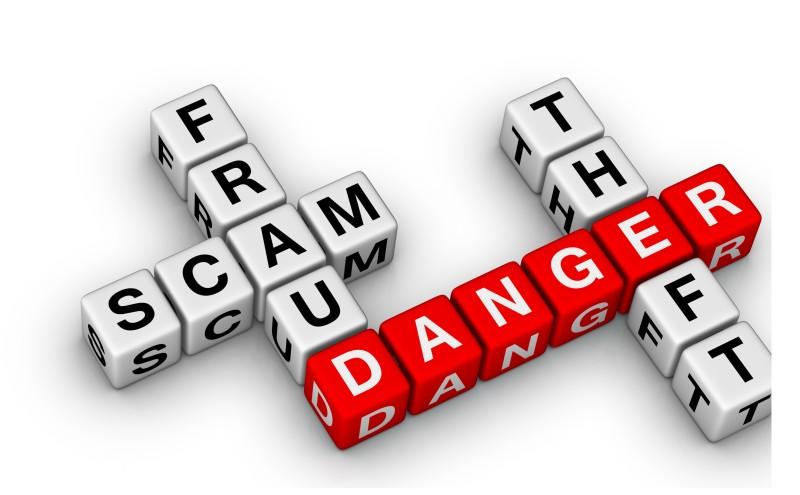 Lettered dice in a "Scrabble" form spelling out the words, danger, scam, theft and fraud. 