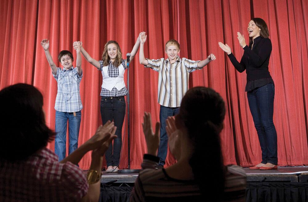 Image of children up on stage taking a bow. 
