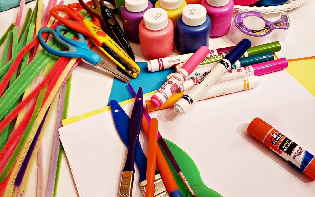 Image of different craft supplies including pipe cleaners, scissors and a glue stick. 