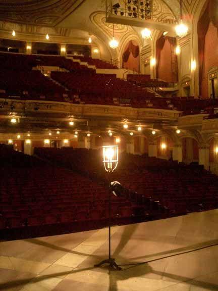 Photo of a Broadway Theater Auditorium. Red seats, gold walls and bright lights.