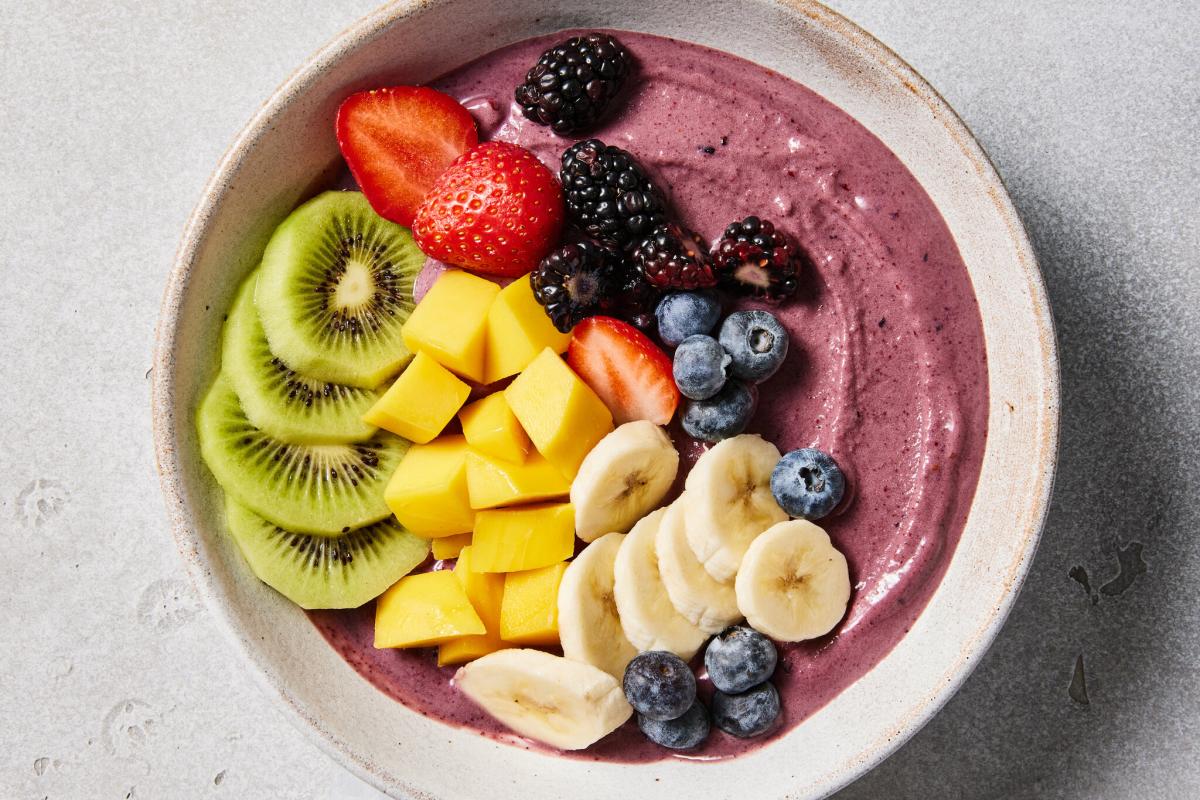 Acai Bowl full of kiwi, mango, banana, blueberries, and blackberries.