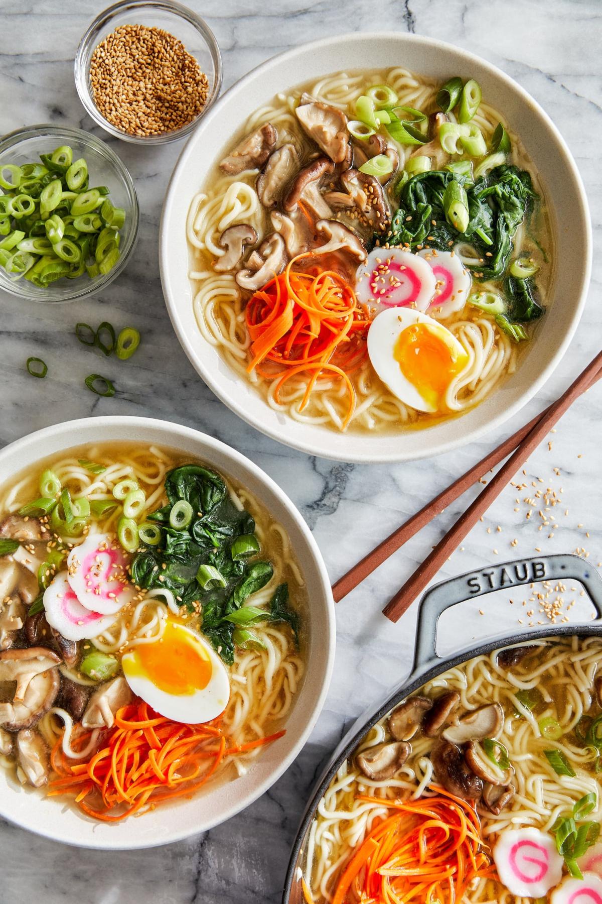 Three bowls of colorful ramen.
