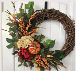 Image of the craft featuring fall colored dried flowers on a round wreath with a bow