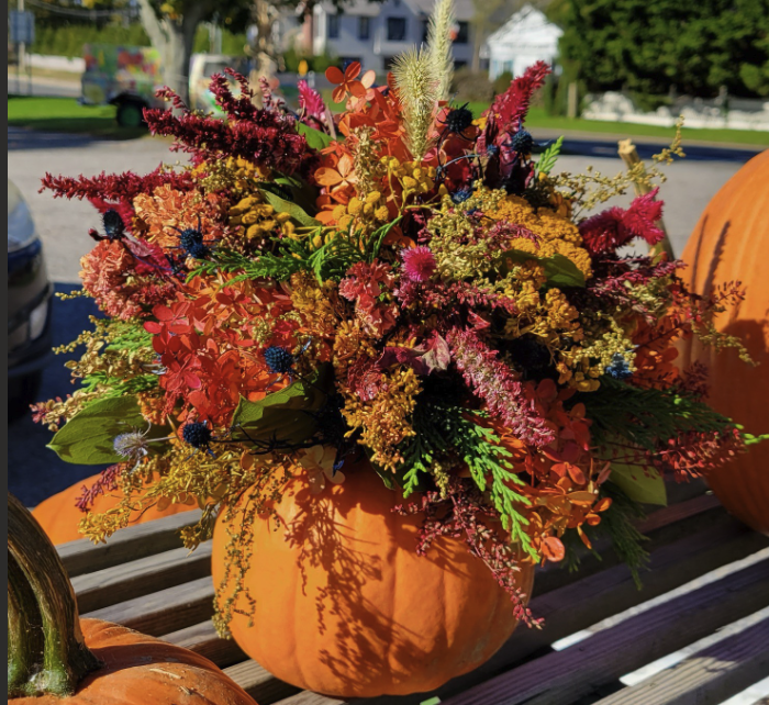 Image of a hollowed out pumpkin with dried flowers in it to create a centerpiece for a table.. 