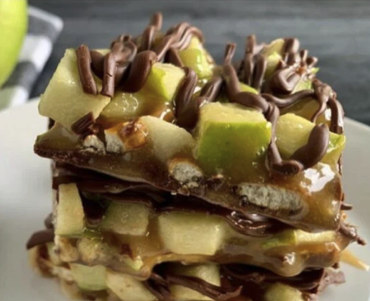 Caramel apple bark made with green apples, pretzels, and caramel on a plate, close up.