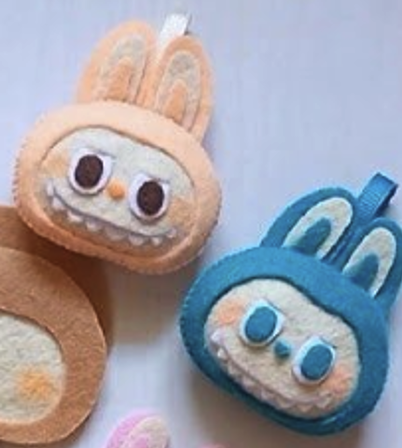 A pink and blue felt Labubu charm