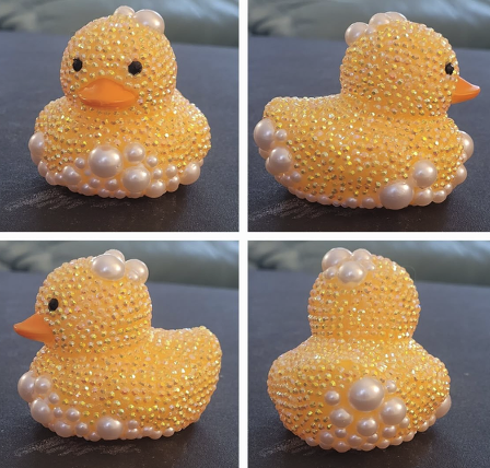 Bedazzled yellow ducks from four different angles, yellows gems and pearl bubbles on them.